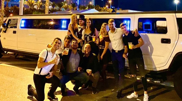 Grupo de amigos celebrando una cena en limusina Hummer en Barcelona.